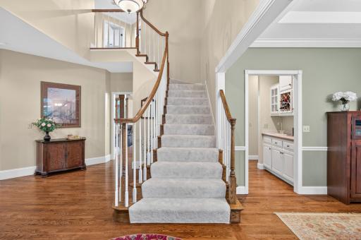 WELCOME- This open foyer/ entry allows the spacious feeling with 18' ceilings, wood floors throughout and an inviting staircase with new carpet just installed June 2026