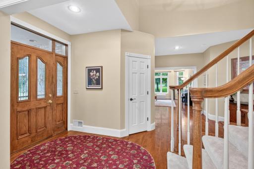 Front ThermaTru wood grain door with sidelites on each side and transoms above. Front foyer closet.