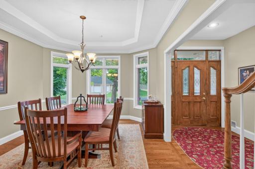 Formal Dining room offers bayed window space with multiple windows, wood floors, trim details plus detailed ceiling