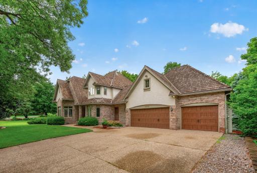 Cedar shake roof, expansive roof lines showing its character and paneled designed garage doors.