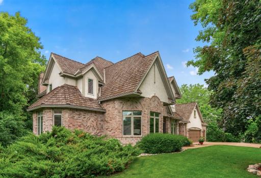 Side view of home showing hard surfaces of Brick and Stucco combo, and transom windows above main level windows