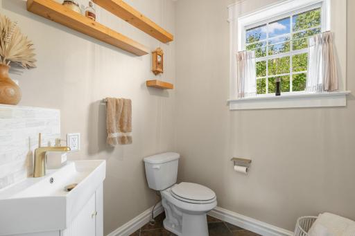 A conveniently located full bathroom completes the main level and features heated tile floors, a single vanity, and a tub and shower combination.