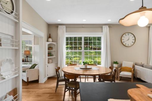 The kitchen flows seamlessly into the bright and inviting dining room, featuring a large picture window and built-in corner shelving.
