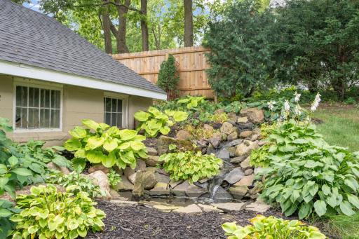 A beautiful water feature adds charm and tranquility near the patio.