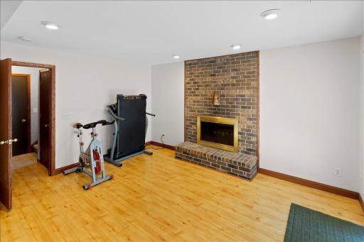 Wood burning fireplace with classic brick surround and raised hearth.