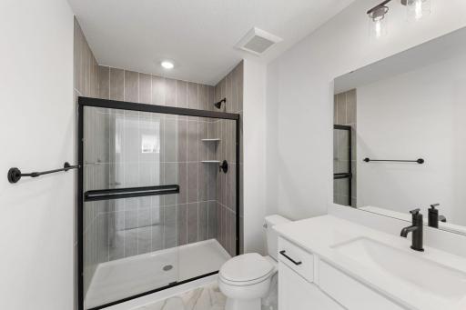 Owner's bathroom features white cabinets and gold hardware