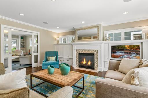 Main level family room with built in cabinetry and gas fireplace. Such an incredible space to enjoy and views into the front living room on the left.