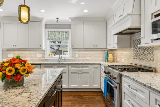 Gourmet range, gas cooktop, custom exhaust hood, stunning granite countertops, tile backsplash and more make this kitchen a true joy to be in.