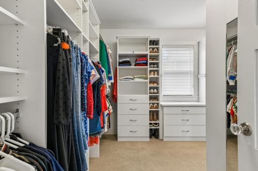 Primary closet with windows adding extra light plus built in organizers to maximize space.