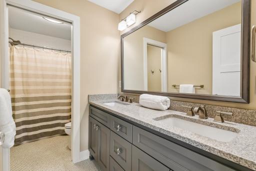 Full upper bath with penny round tile floors, dual granite vanity and separate tub and stool area with pocket door for ease of two to get ready at the same time yet offer privacy.