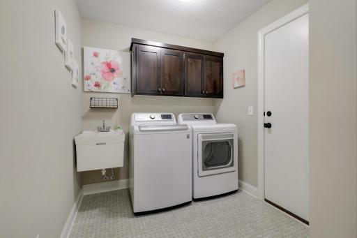 Walk-thru laundry with a sink, cabinets and closet has access to the garage (washer and dryer included)