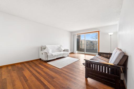 Large open living room with nice flooring and sliding glass door to private covered porch