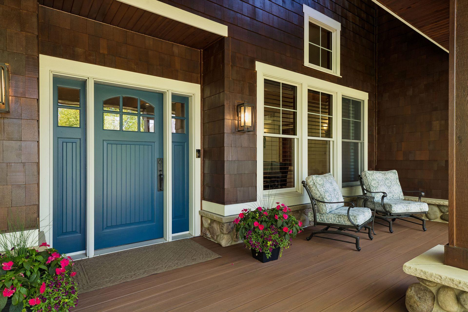 Charming front two-story covered porch with new TimerTech decking (2025), freshly stained cedar shake siding (2025), stone accents, copper gutters & a stamped concrete walkway & concrete driveway border.