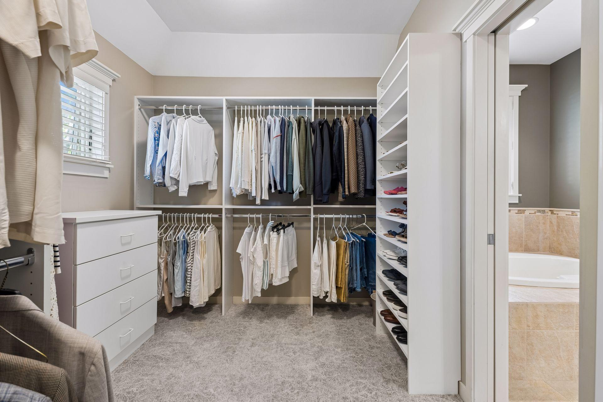 Keep your entire wardrobe organized in the large walk-in closet (14'3" x 8'7"). The built-in organizational system includes hanging racks, a dresser, shoe storage, & cubies. The room includes a pan ceiling & window to fill it with natural light.
