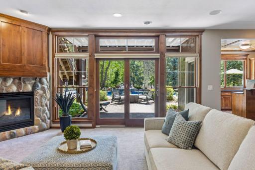 Stunning view of the backyard from the patio door surrounded by windows. The large paver patio (25' x 25') is partially covered under the deck & includes the perfect firepit area.