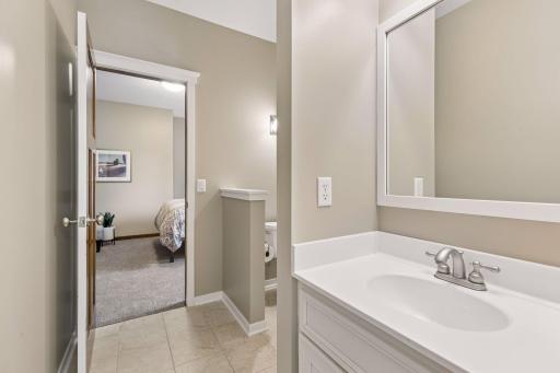 The shared ensuite Jack & Jill full bathroom includes a vanity with storage & a storage cabinet & ceramic tile floors.