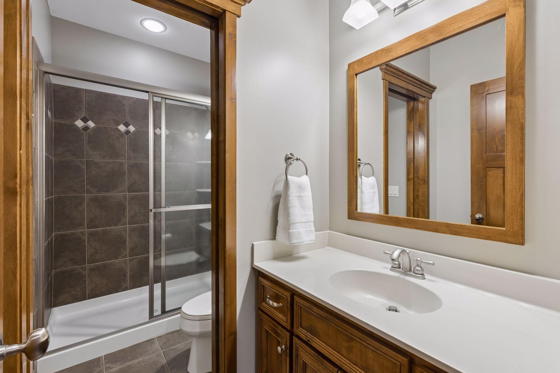 A convenient 3/4 bathroom is located just off the family room & one of the 3 lower-level bedrooms. It features a large vanity w/storage, ceramic tile floors, a shower surround & a pocket door to the separate shower & stool.