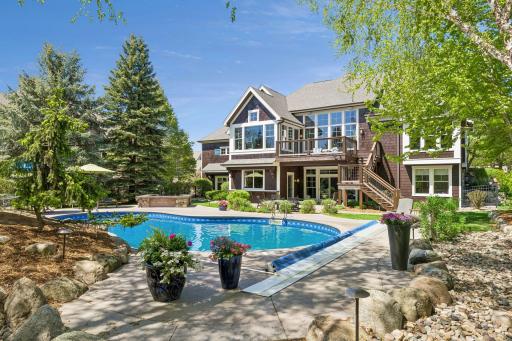 Your own private, wooded resort-like backyard! It features a heated saltwater pool, built-in hot tub, stone waterfall feature, professional landscaping, a large TimerTech deck (2025) & paver patio w/firepit area.