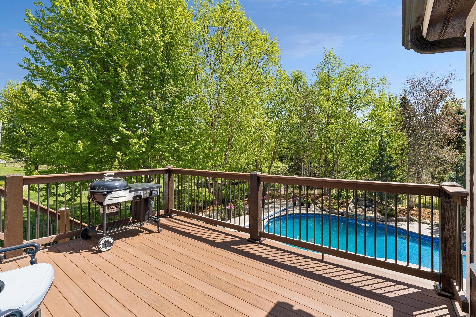 Another view of the backyard deck, including the pool and surrounding yard. The stairs leading to the backyard are lit for safety and ambiance.