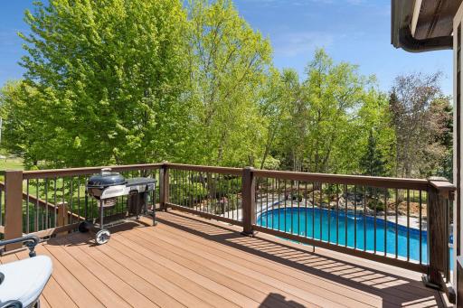 Another view of the backyard deck, including the pool and surrounding yard. The stairs leading to the backyard are lit for safety and ambiance.