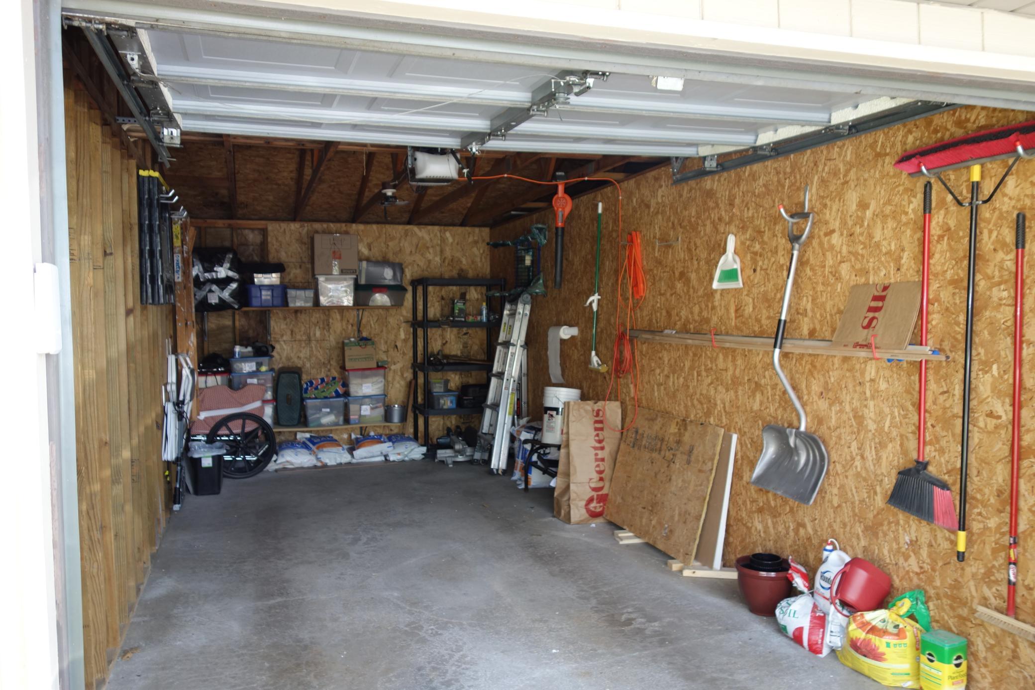 This garage has extra storage shelving and a keyless entry pad.