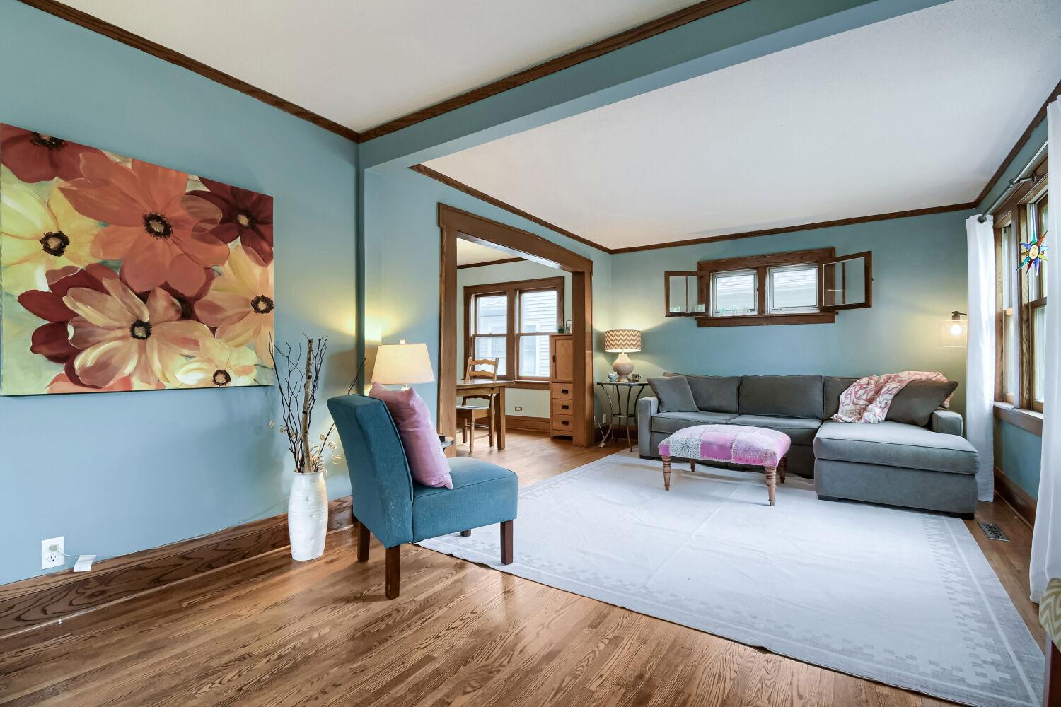 Welcoming, open living room with hardwood floors and natural woodwork.