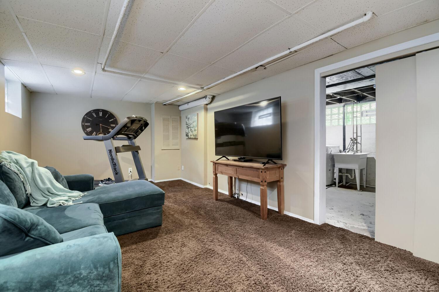 Lower level family room with a peak into the laundry room