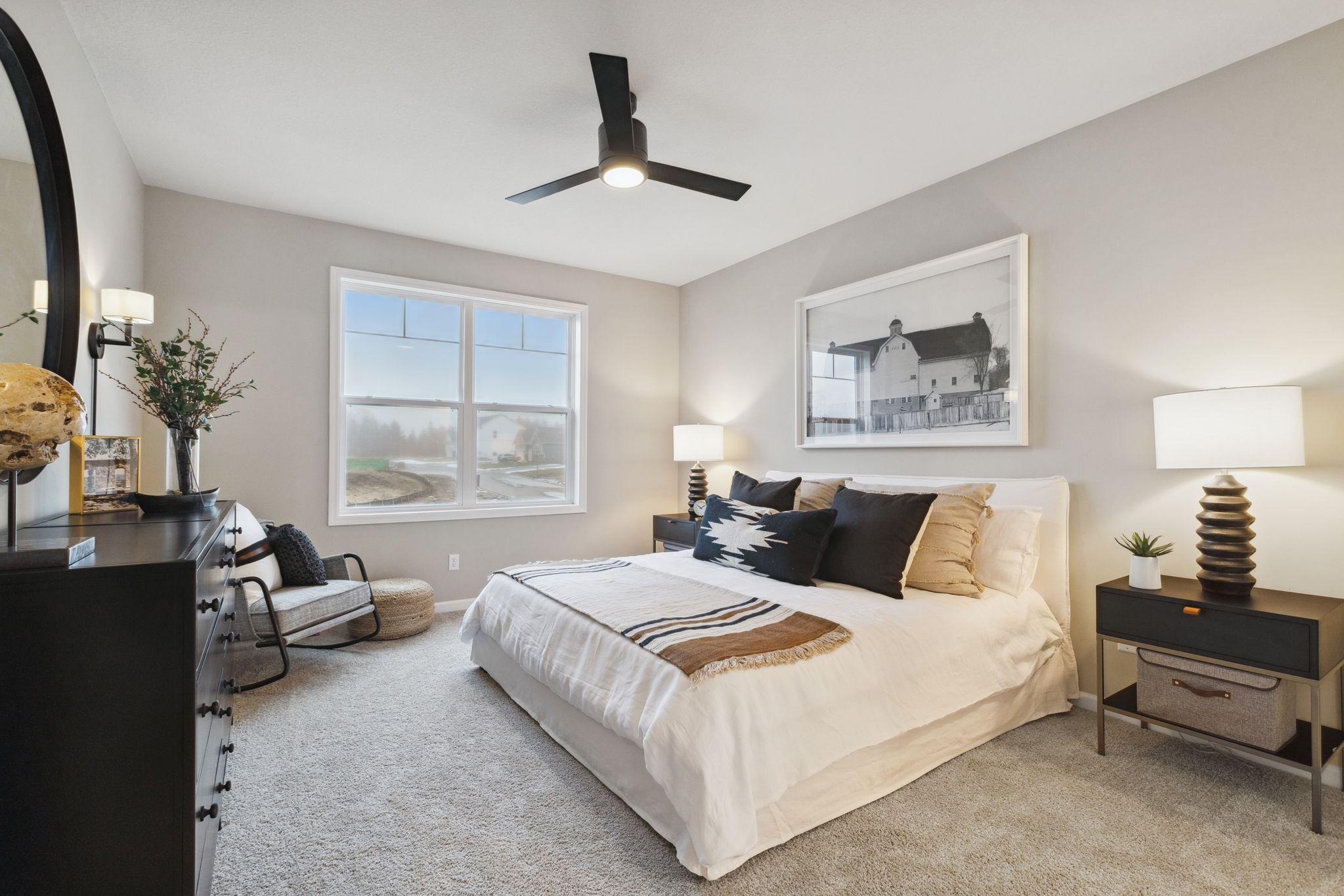 The expansive owner's suite located on the main level is the perfect getaway to recharge, relax and renew. Photo of model home, colors and options may vary. See listing agent for details.