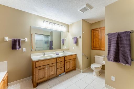 Owner's bath with raised, double vanity. Shower is opposite vanity.