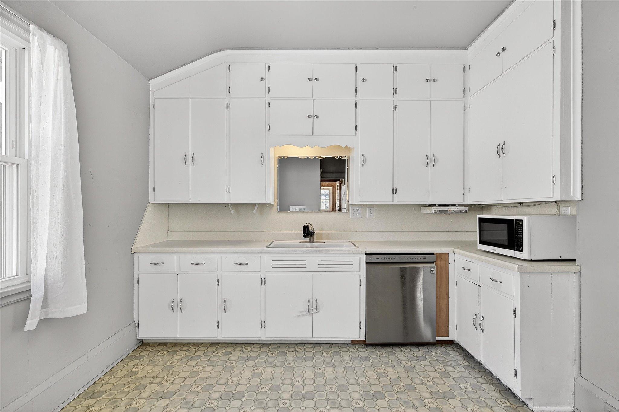 Seller added a dishwasher & garbage disposal to this functional kitchen space.