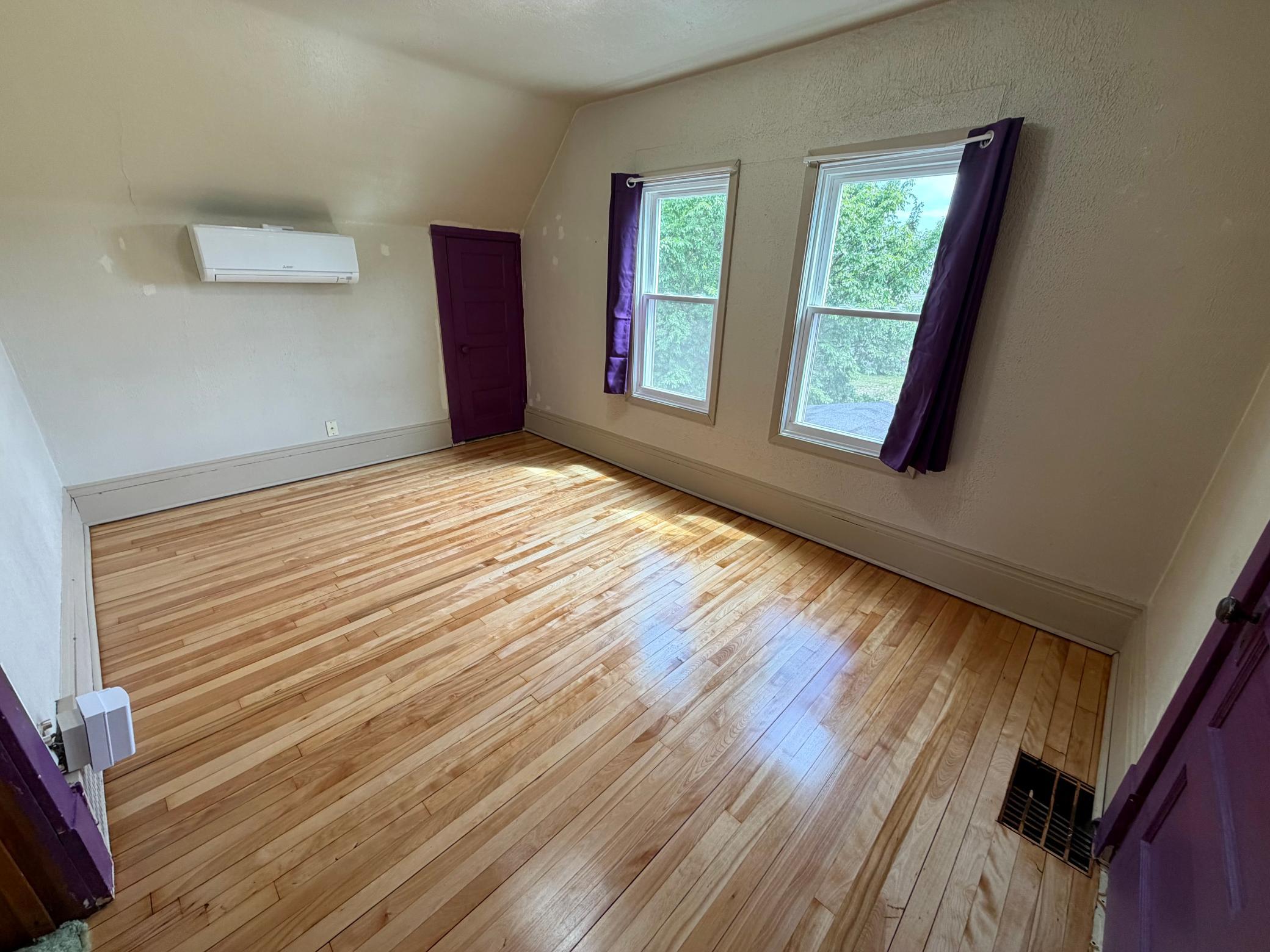 One of the two upper level bedrooms with gleaming refinished floors.