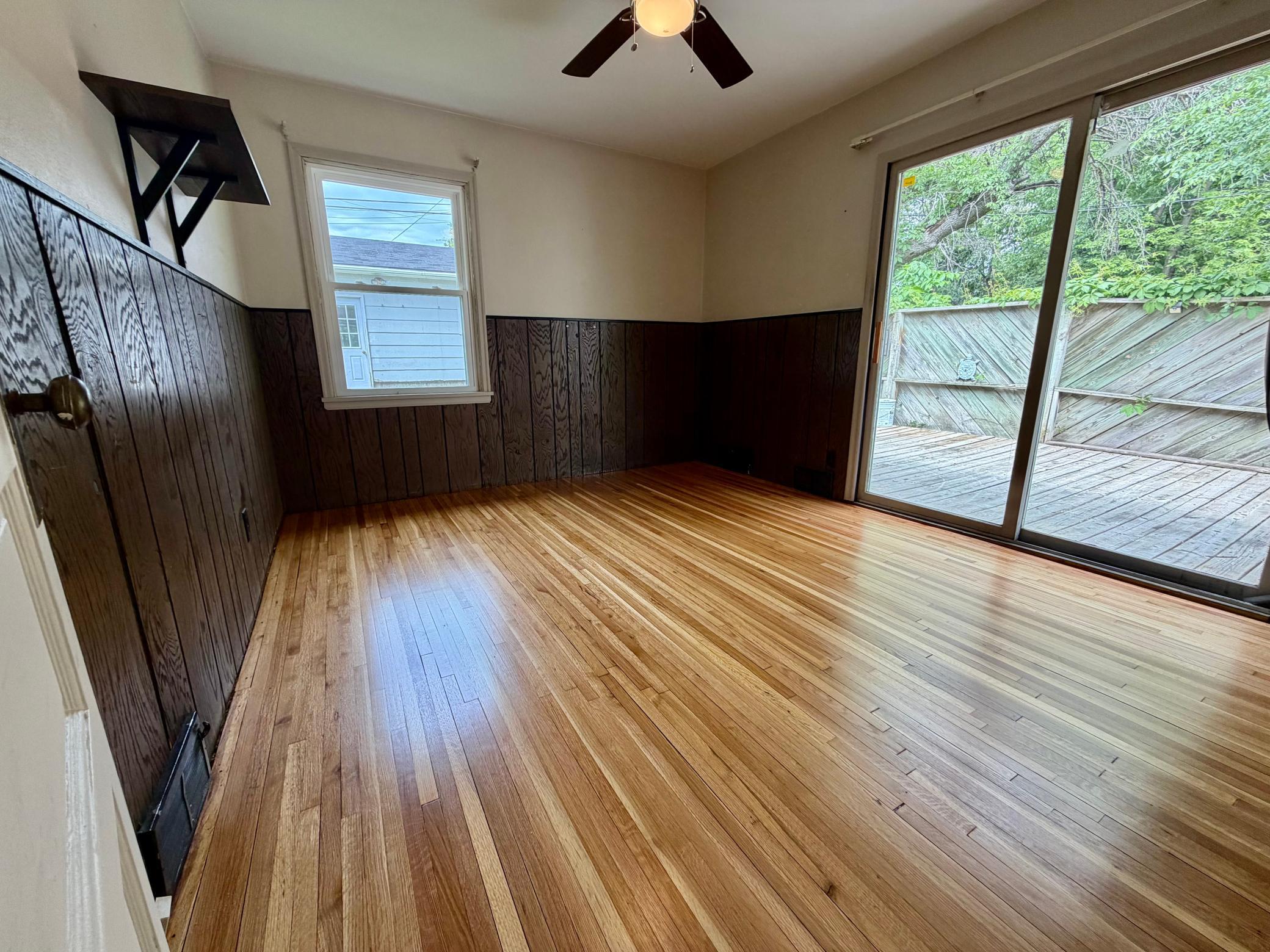 This main level room functions as a flex room, or a 4th bedroom if the side door to the home is utilized instead of these sliders.