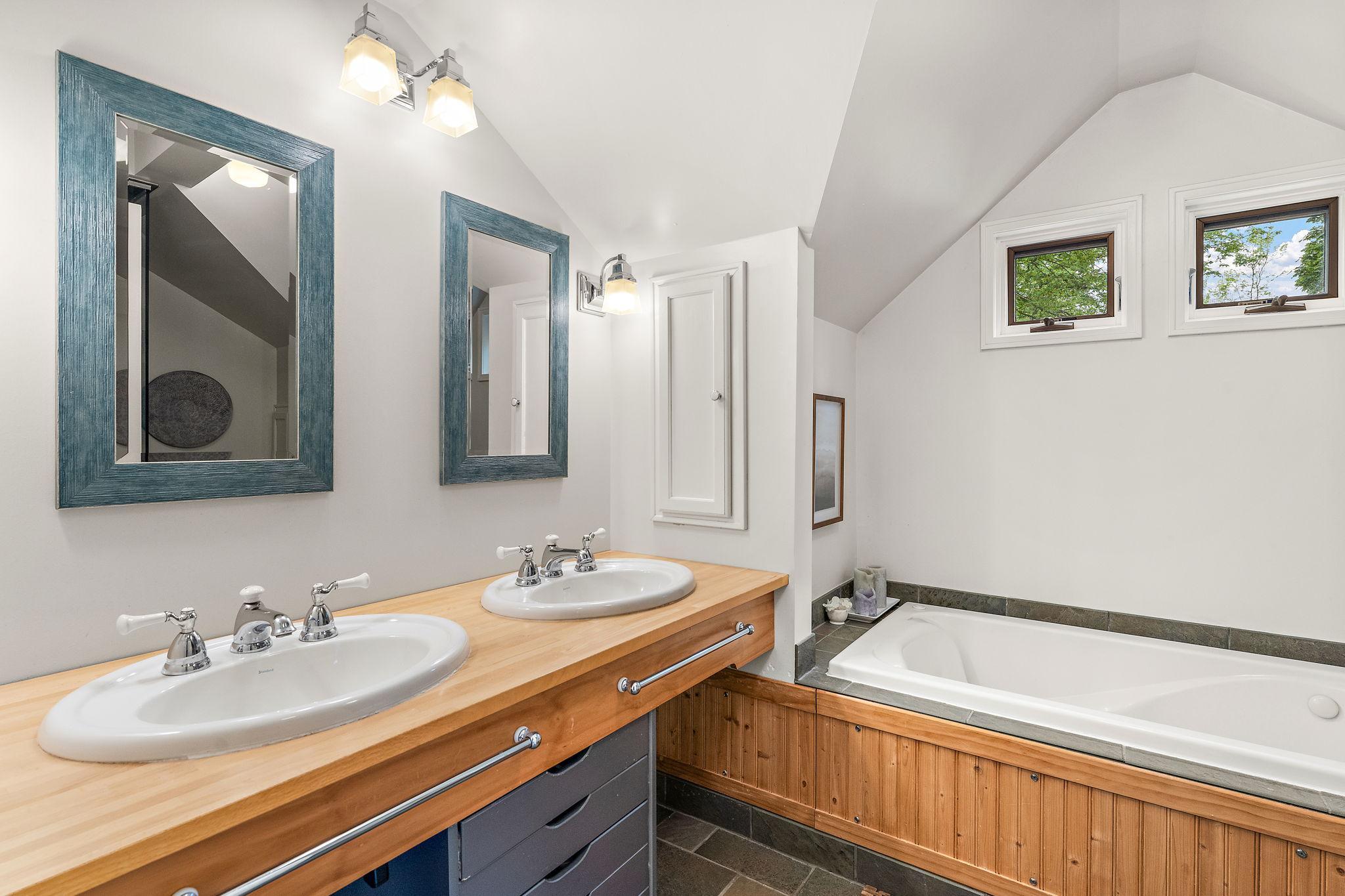 Upper full bath with double sinks and a soaking tub. .