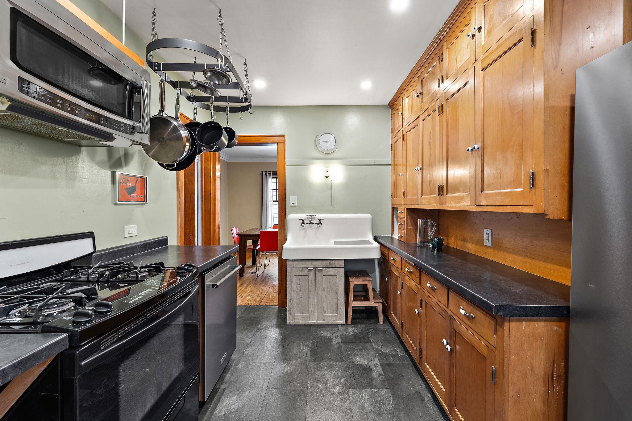 So. Much. Character. This kitchen blends original with new. Gas stove, dishwasher, slate tile floors blended with original cabinets and sink.