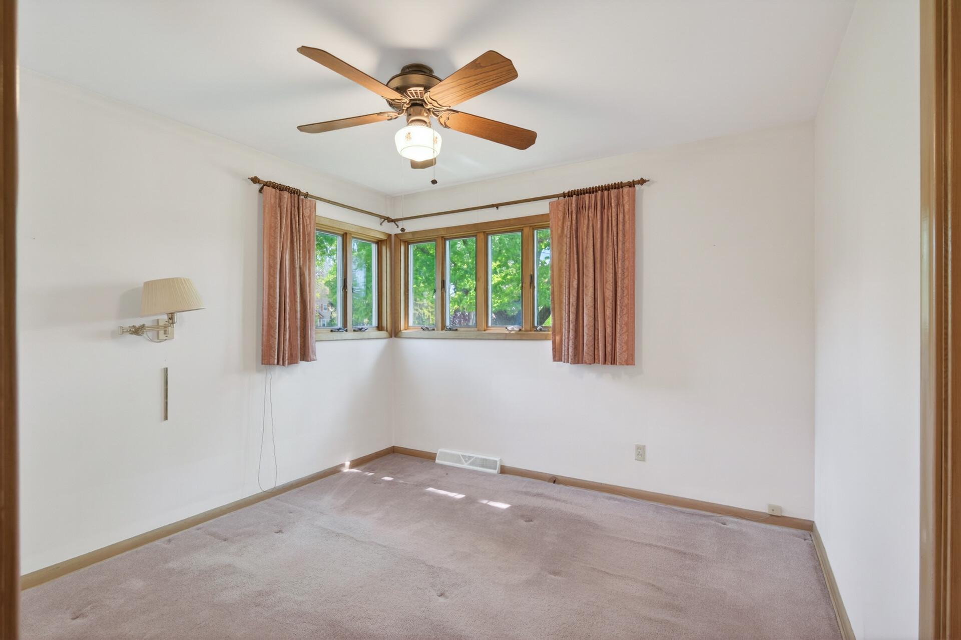 The primary bedroom has a ceiling fan and a oversized Andersen corner window.