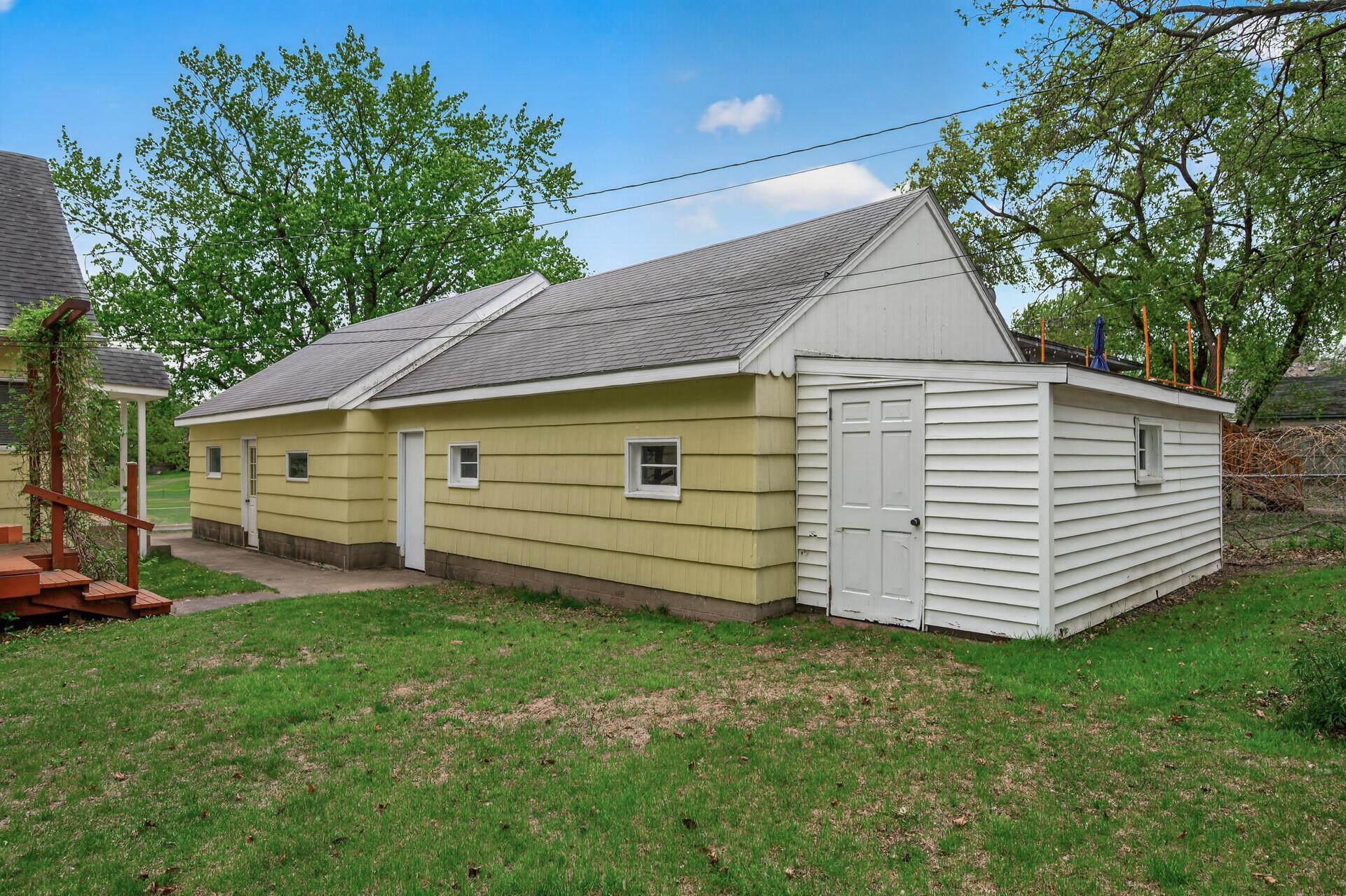 A rear yard view of the 4 car garage and lean to.