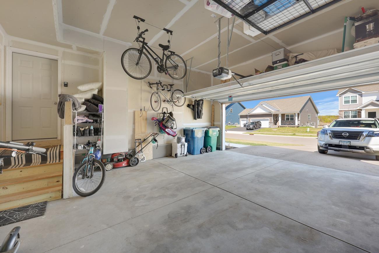 Clean, sheet-rocked garage with storage space