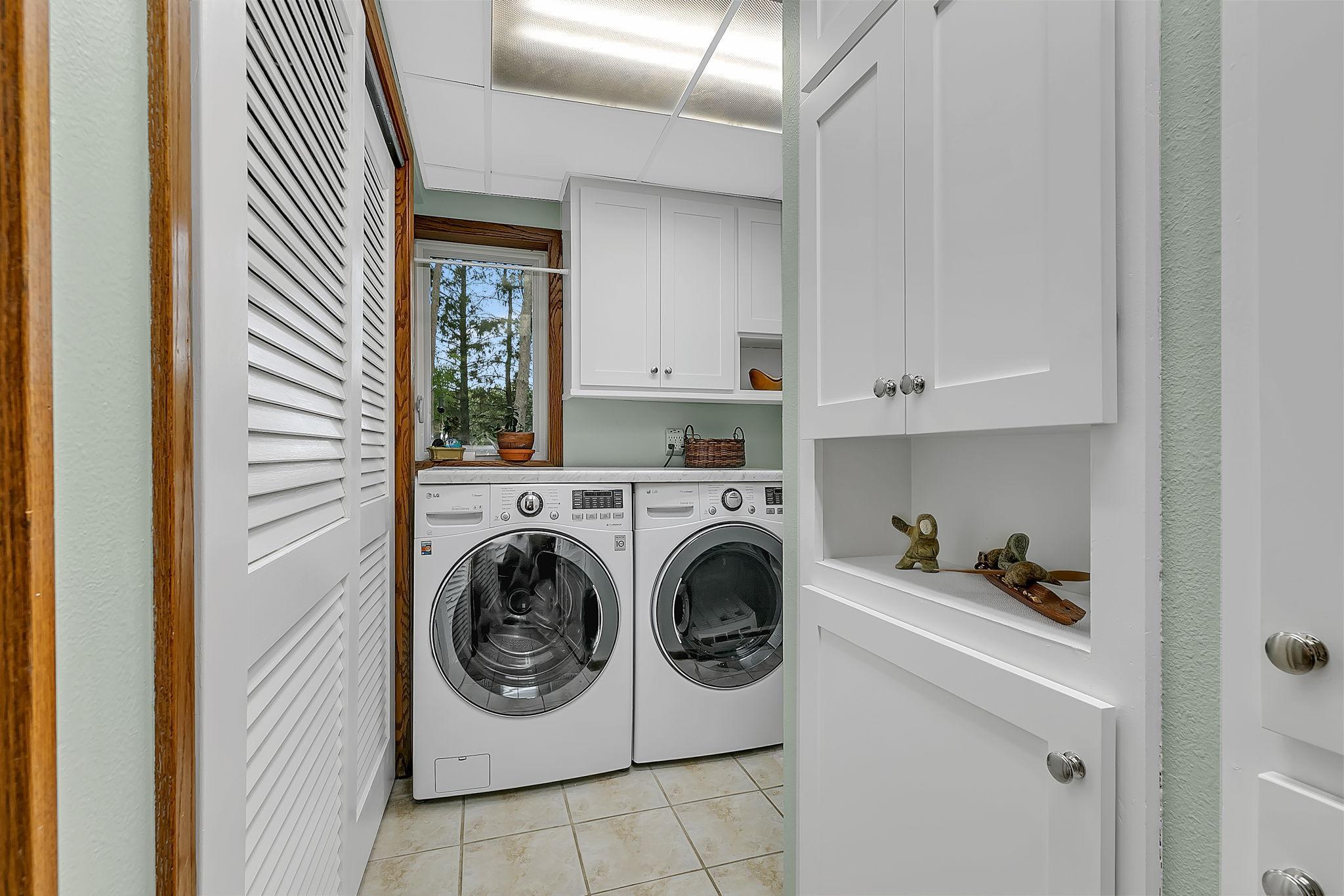Light and bright laundry room with lots of storage!