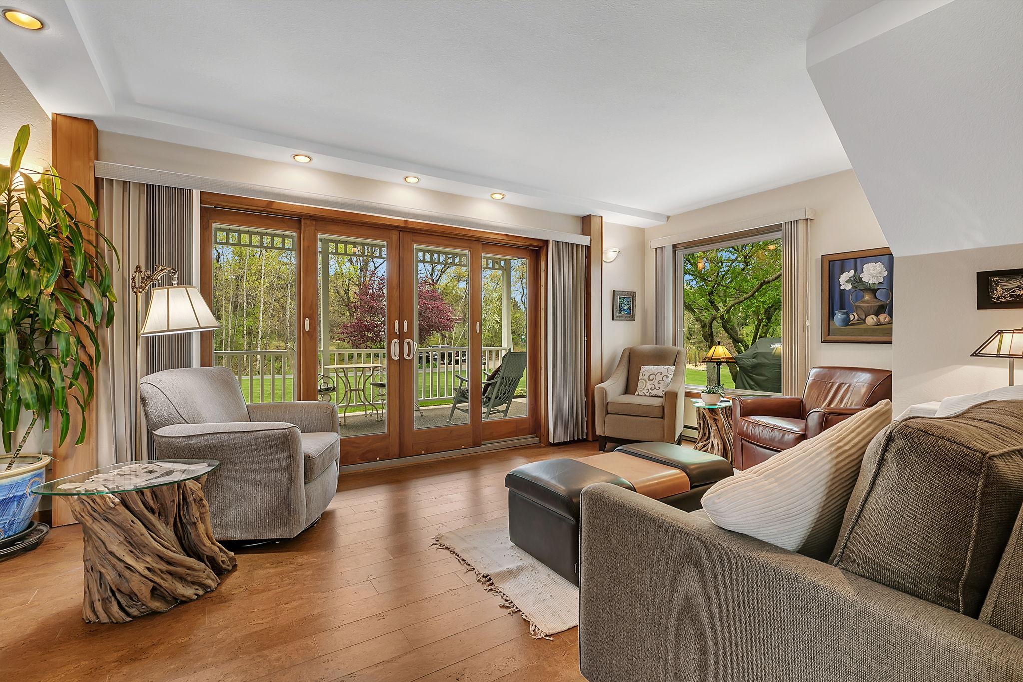 Main level living room boasts patio doors to the covered front porch