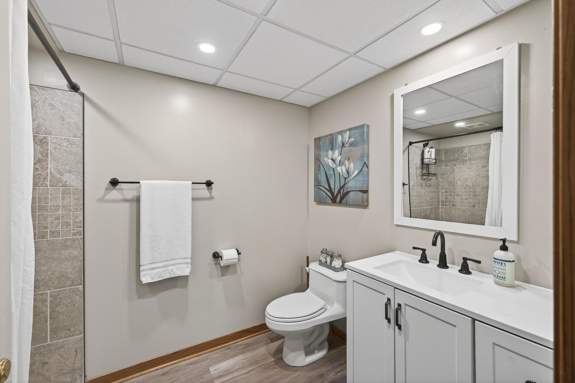Lower level remodeled bathroom, with tiled walk-in shower.