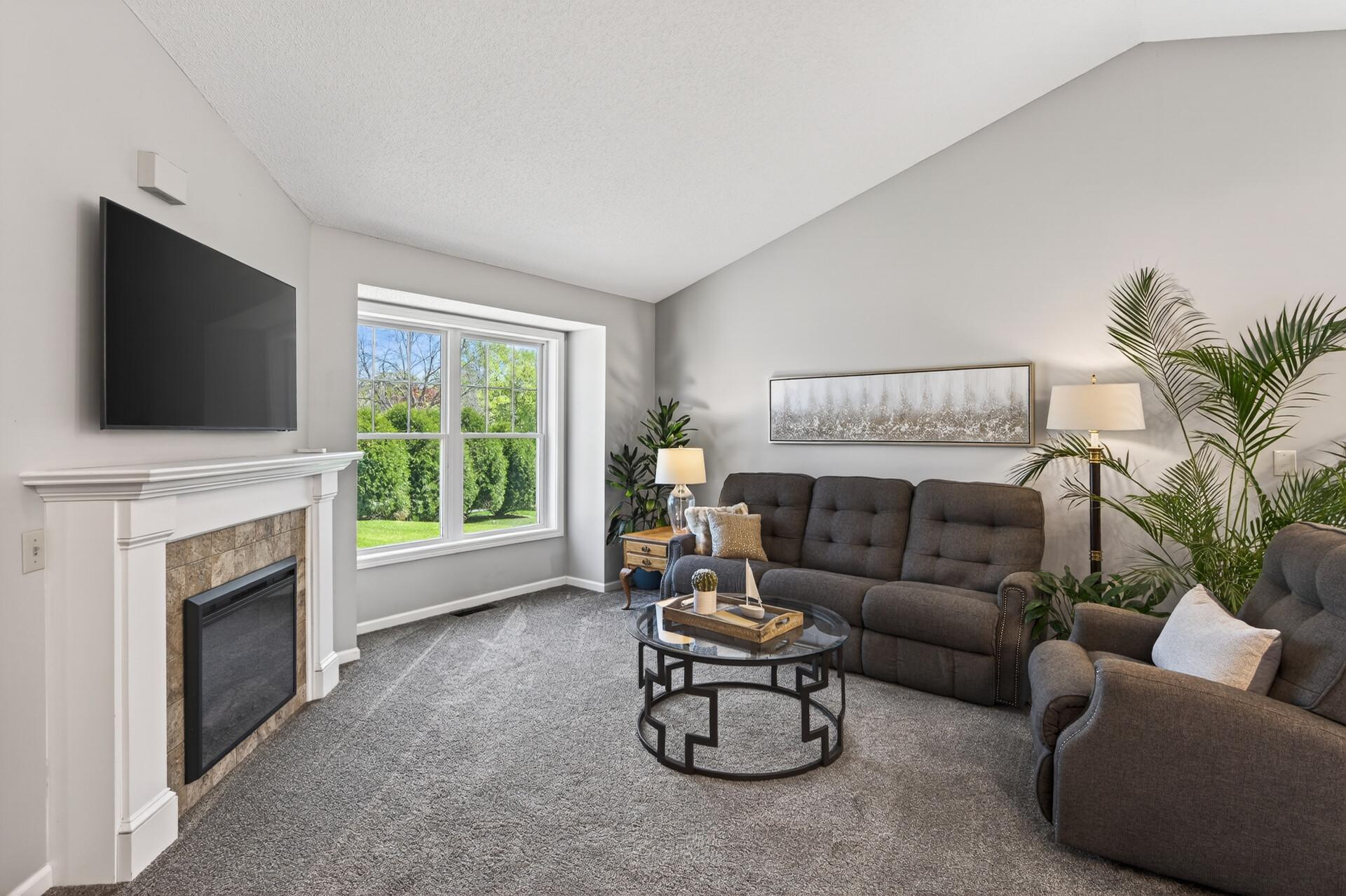 Bright and open living Room with gas burning fireplace, and vaulted ceilings.
