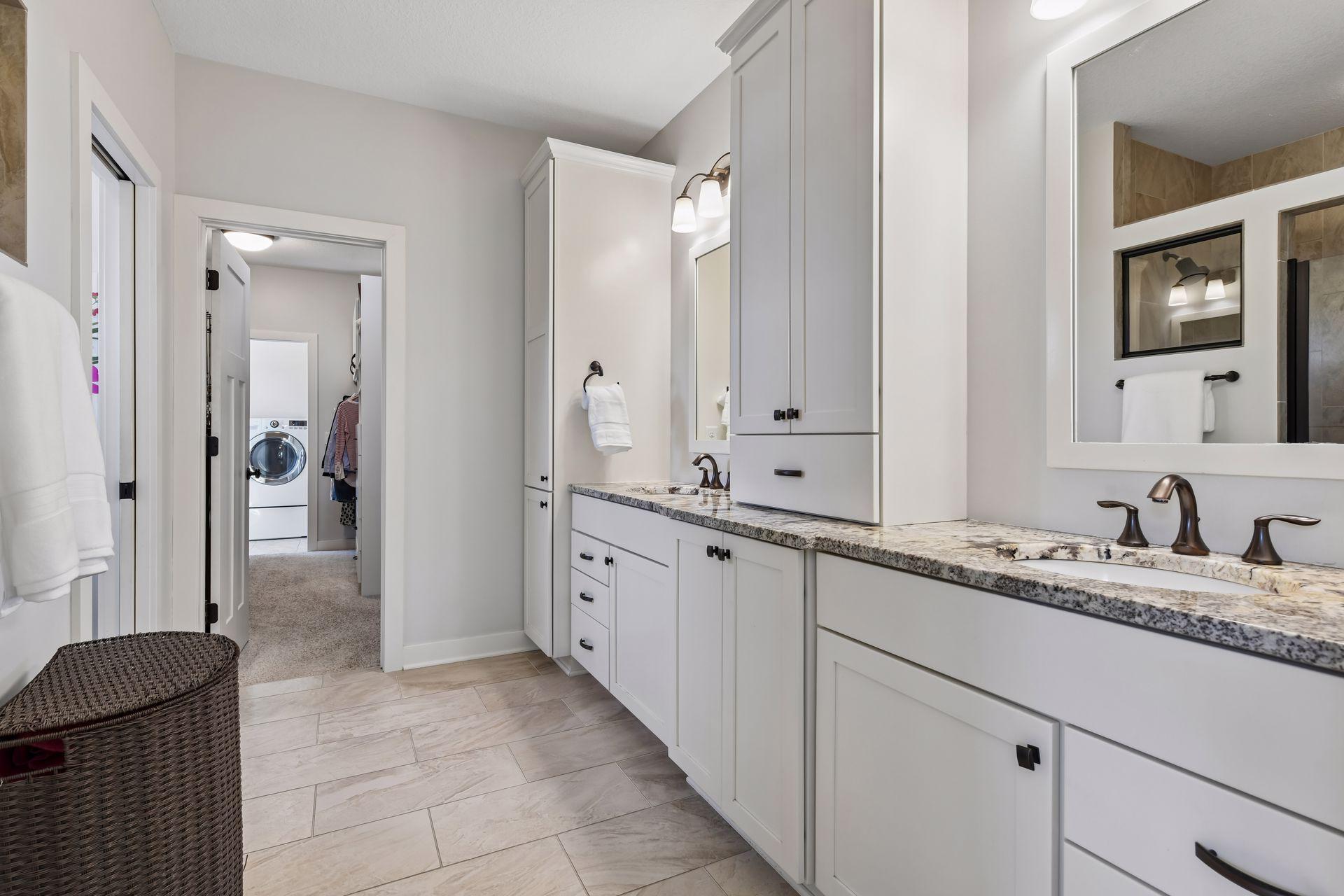 The homeowner's primary bathroom en suite has a large walk-in tile shower to the left as well as an enclosed space for the commode (neither are shown here).