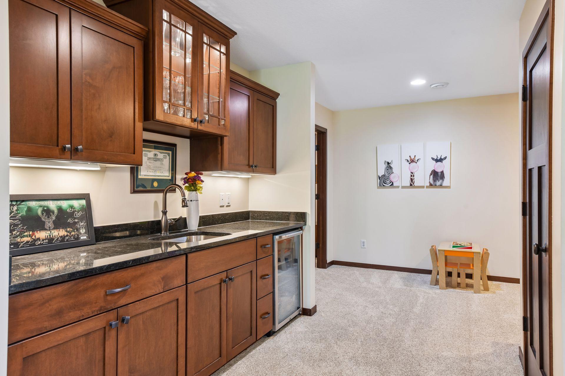 At the foot of the stairs is a wet bar which includes a wine refrigerator, sink and more storage cabinetry.