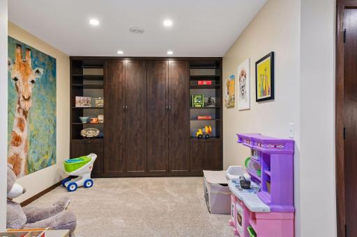 Around the corner from the wet bar is a bonus area featuring even more built-in cabinetry. Currently furnished as a children's play area, this area could easily accommodate an office, music room or craft area.