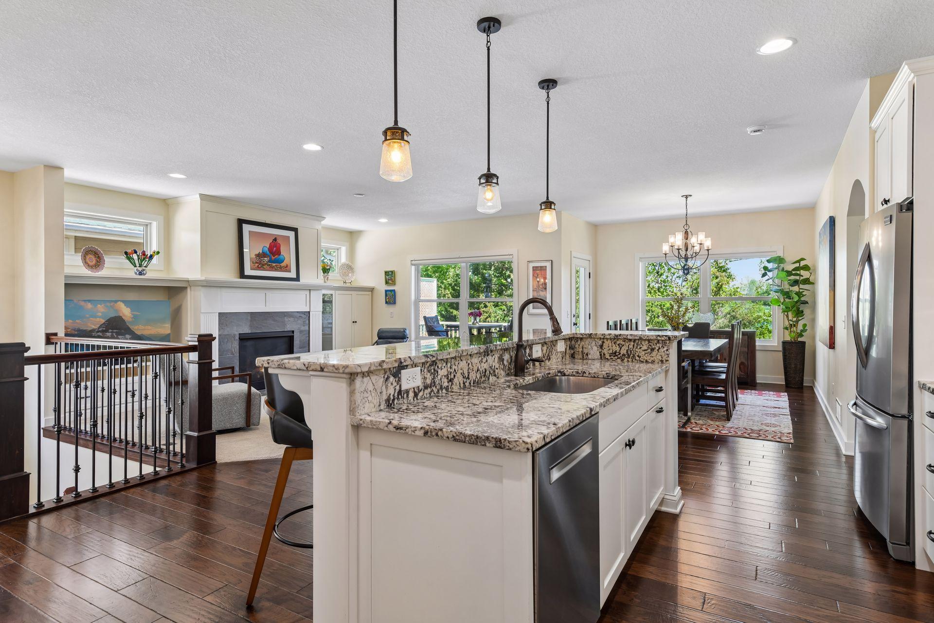 The kitchen is well-appointed with granite countertops, double wall ovens, a french door refrigerator, and a large gas cooktop.