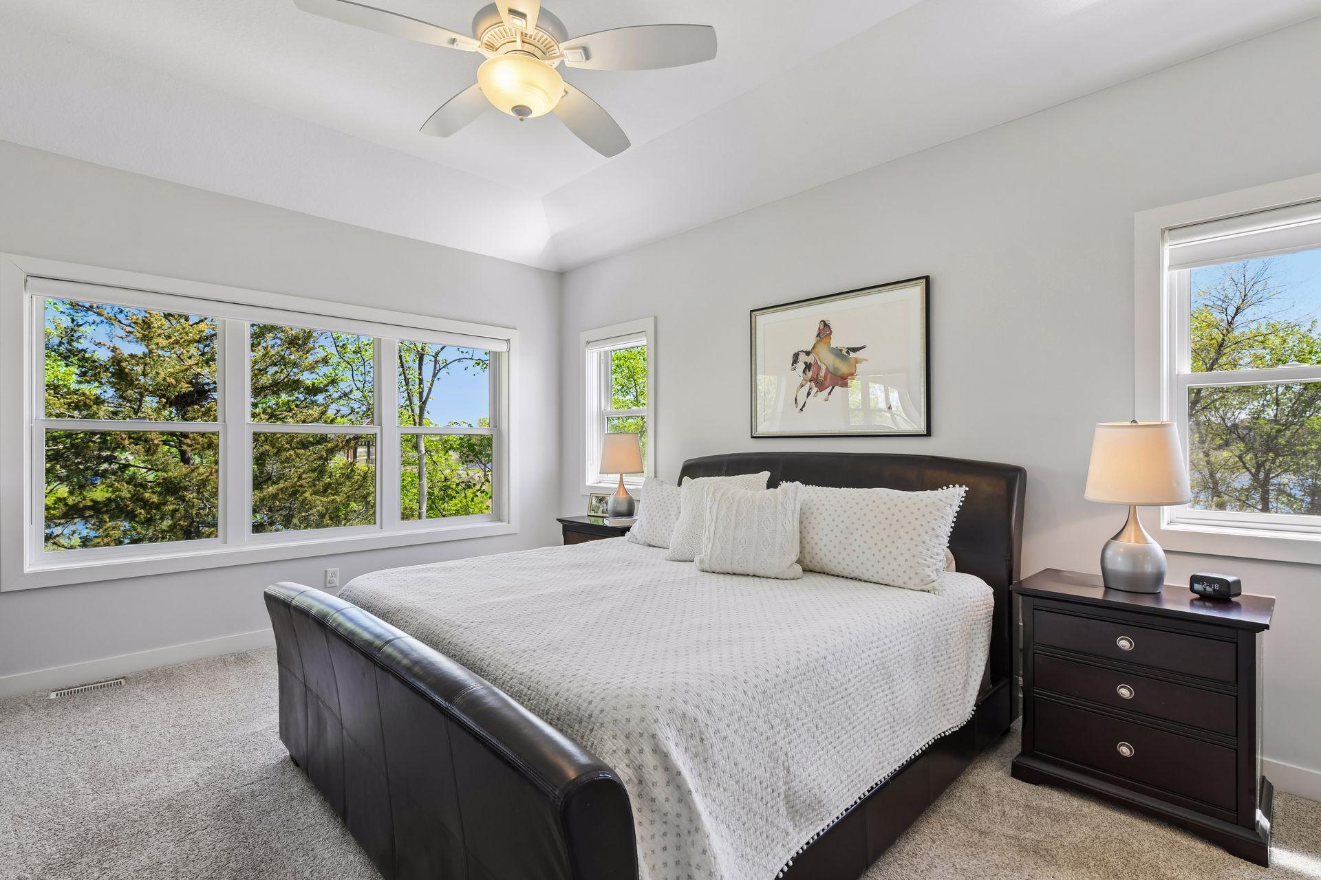 The main floor primary bedroom has large windows that faces east and have views of nature. The smaller windows facing south look at a large pond.