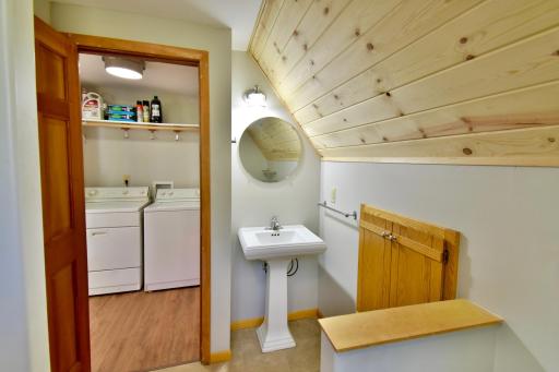 The bathroom is located just off the laundry hallway.