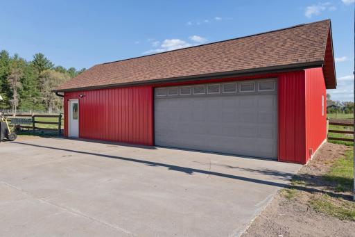 Ag/shop out building with overhead doors, newer shingles, and concrete floor.
