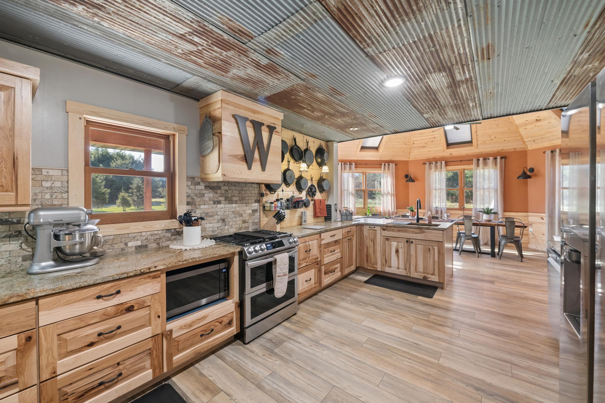 Rustic patina ceiling treatment and Vinyl plank flooring accent the kitchen
