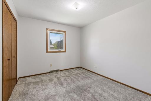 The third bedroom on the main level is ideal for guests, family, or a home office setup.